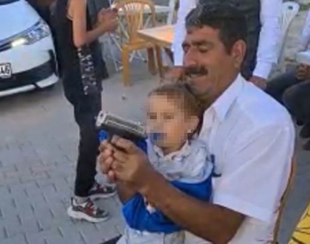 Ağzında emzikli torununun eline silah verip ateş ettirdi