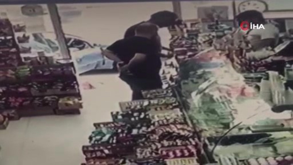 Alkol kutusunu pantolonunun arkasına sokup çalan hırsız kamerada