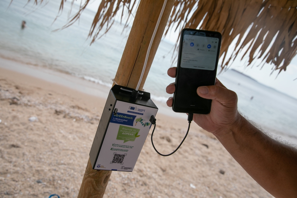 Atina plajlarında güneş enerjili telefon sarj şemsiyeleri