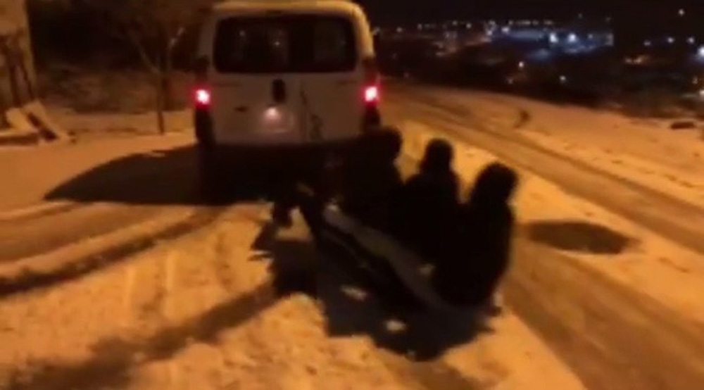 Buzlanan sokakta gençlerin tehlikeli oyunu