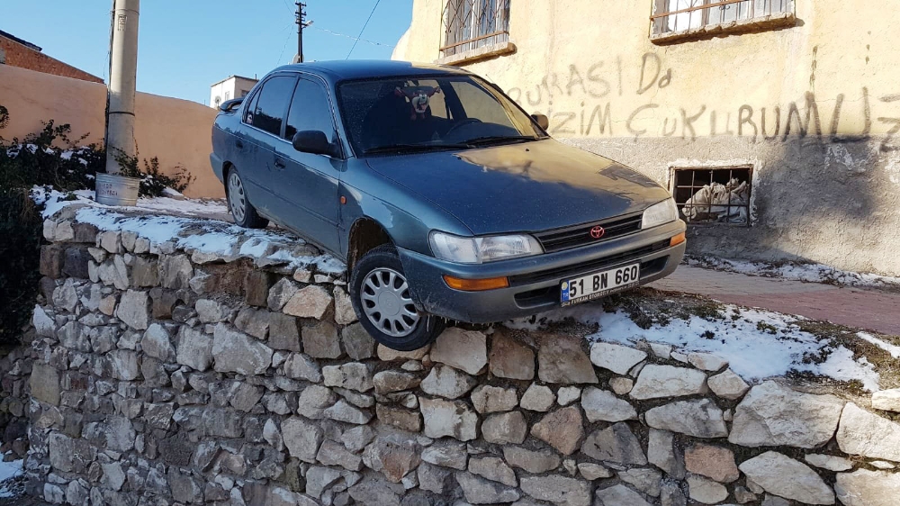 Buzlanmadan dolayı kayan otomobil duvarda asılı kaldı