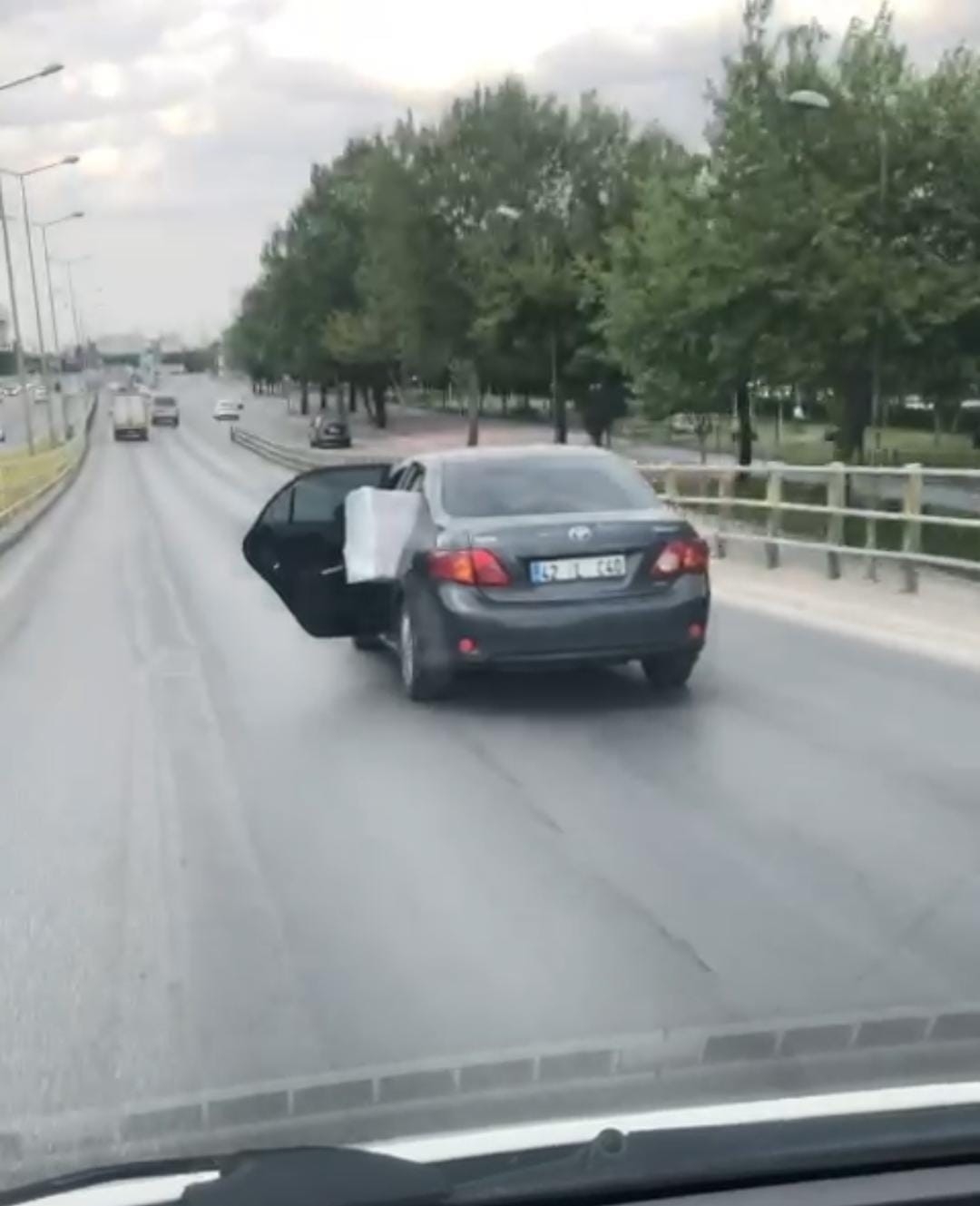 Eşya yüklü otomobilin arka kapısı açık haldeki yolculuğu kamerada