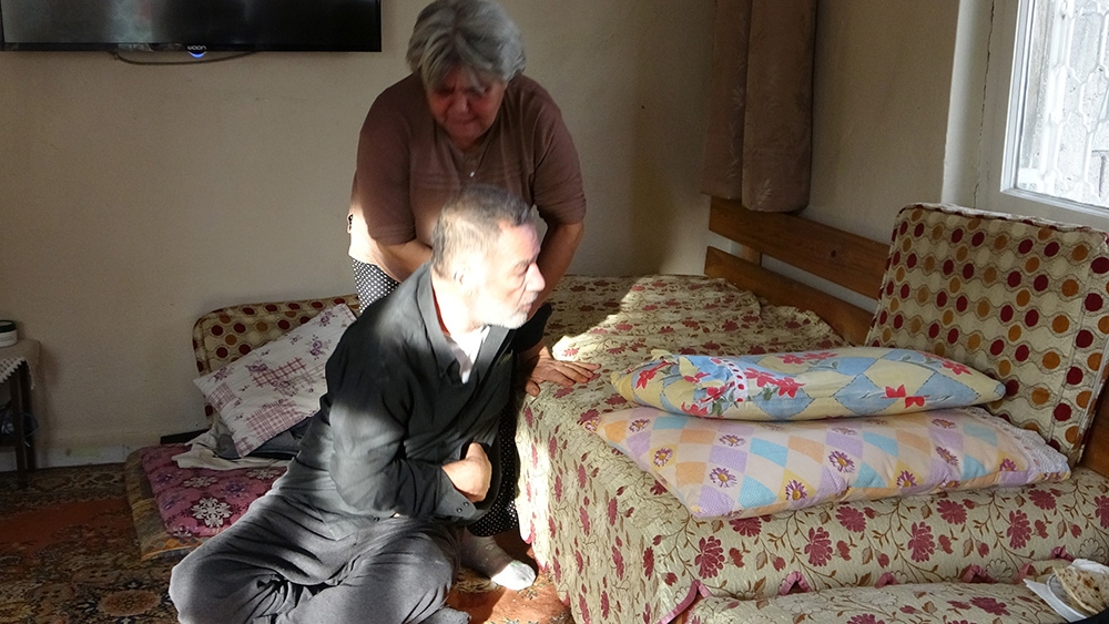 Felçli eşine bebek gibi bakıyor