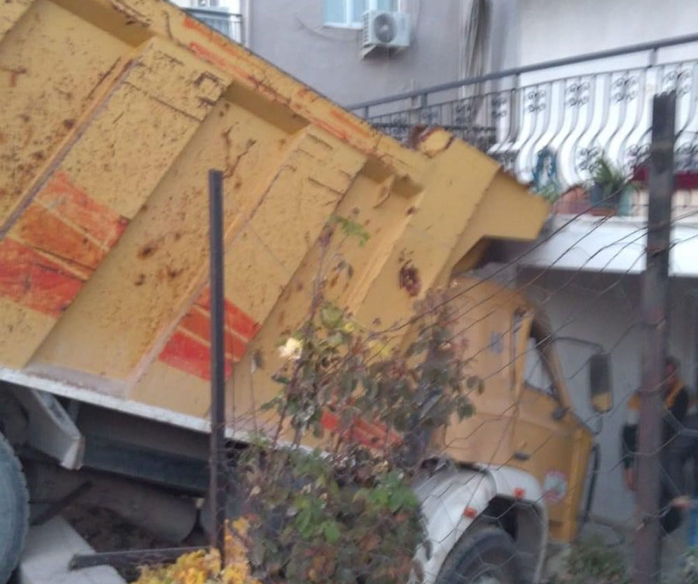 Freni boşalan hafriyat kamyonu ev ve yol arasında asılı kaldı