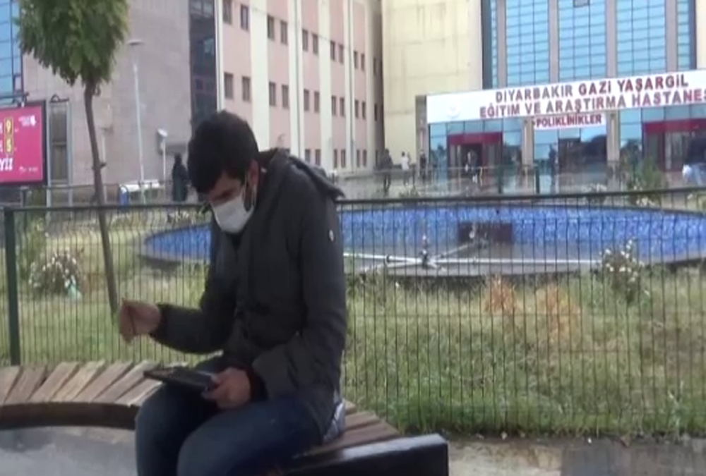 Hastane bahçesindeki banklarda uzaktan eğitimle ders veriyor
