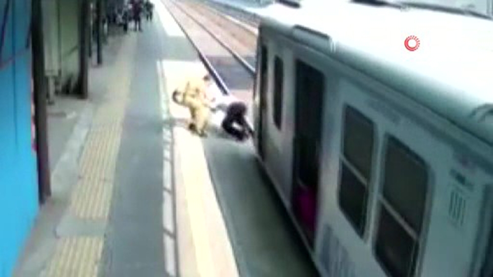 Hindistan’da polis, bir kişiyi trenin altında kalmaktan son anda kurtardı
