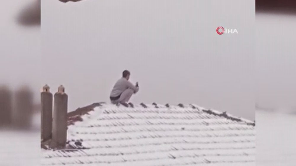 Kar fotoğrafı çekmek için canını tehlikeye atıp çatıya çıktı