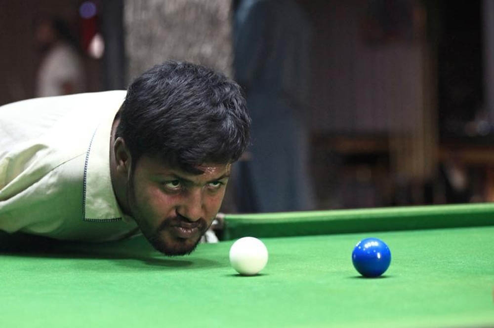 Kolları olmayan adam çenesiyle bilardo oynayarak hünerlerini sergiliyor