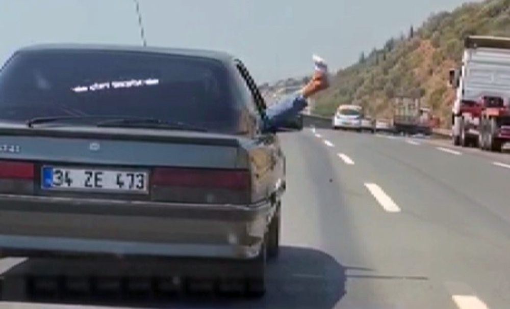 Otomobilin camından bacağını sarkıttı: Bu nasıl yolculuk ?