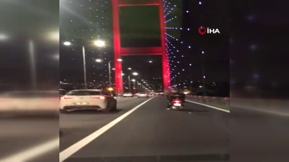 Şiddetli rüzgarda köprüden geçen motosikletliye kalkan oldular