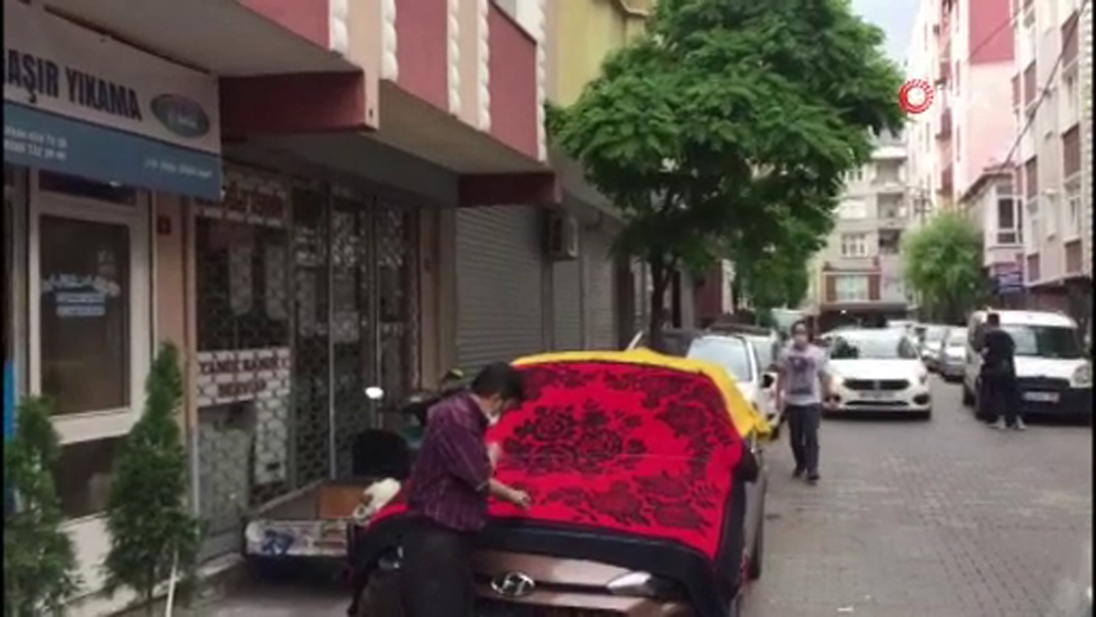 Vatandaşlar dolu yağışına karşı arabalarını halıyla örttü