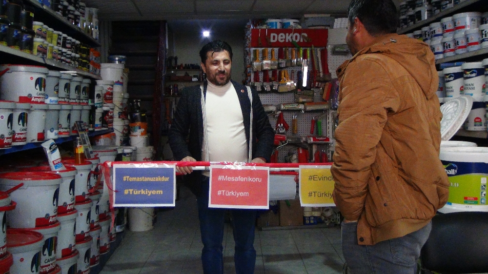 Virüsten korunmak için 1,5 metrelik su borusu ile dolaşıyor