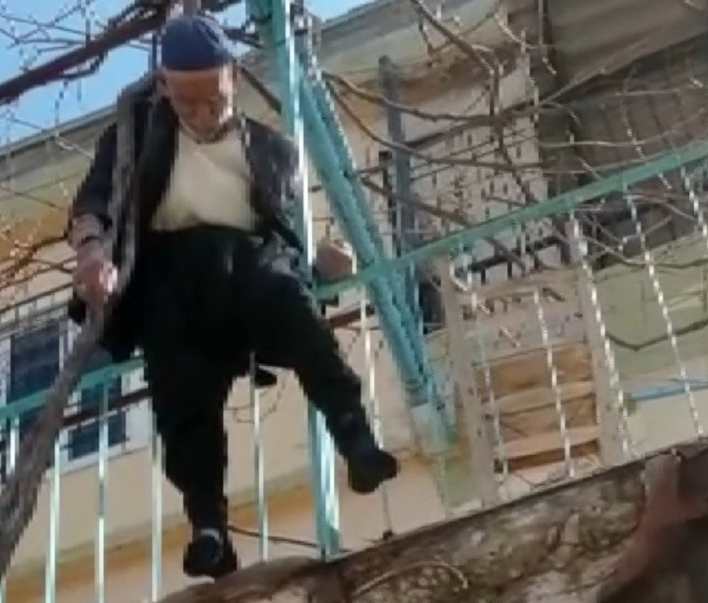 Yaşlı adam çıktığı ağaçta asılı kaldı